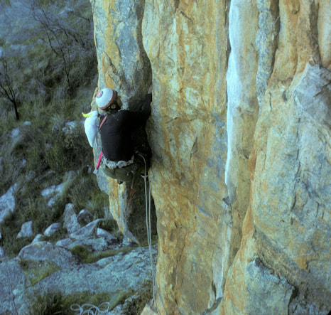 Roland Pauligk on Christian Crack, Mt Arapiles (20/5.10c) in 1975. He has a target on his helmet so that falling rocks will miss it. Photo Credit: Bill Andrews